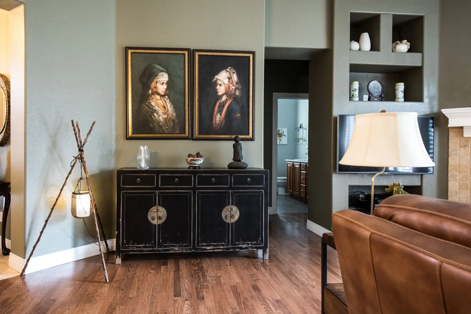 Klassieke salon met saliegroene wanden en een gelakte kast.